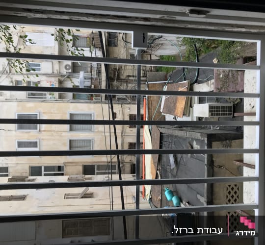 סורגי חלון עם נוף של בניינים ברקע